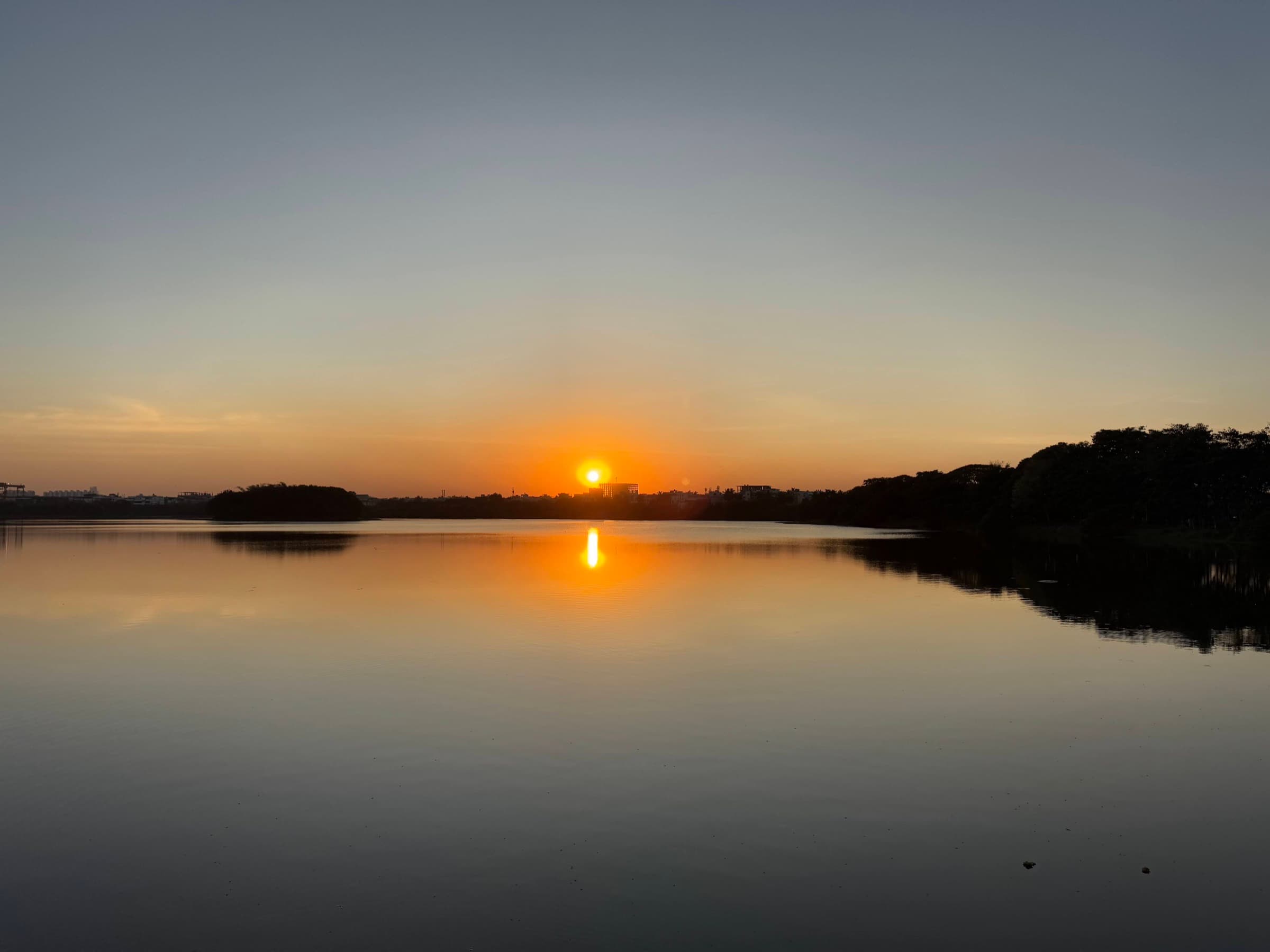 Sunset reflected in a still Bengaluru lake